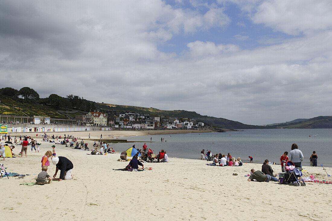 Leute entspannen am Strand, Lyme Regis, Dorset, England, Großbritannien