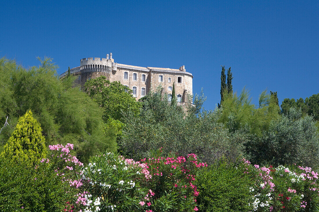 Das Schloss Château Suze-la-Rousse hinter blühenden Büschen und Bäumen, Drome, Provence, Frankreich