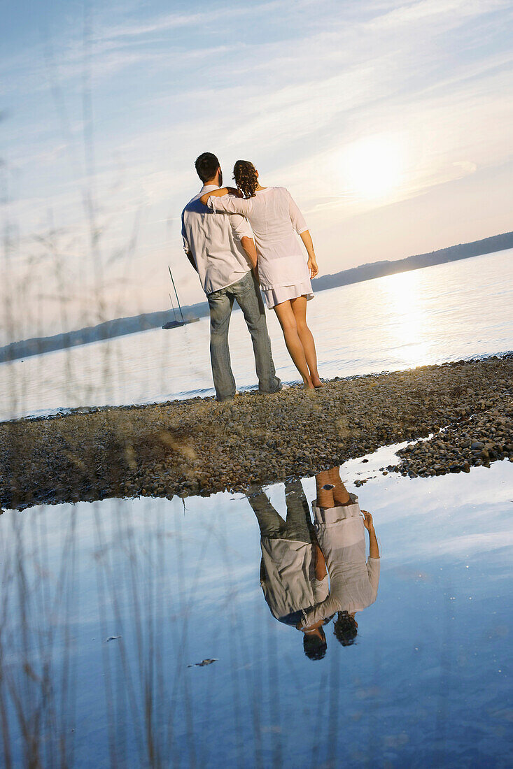 Couple standing at lakeshore, Ambach, Lake Starnberg, Bavaria, Germany