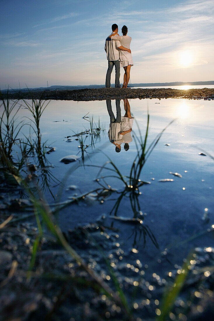 Couple standing at lakeshore, Ambach, Lake Starnberg, Bavaria, Germany