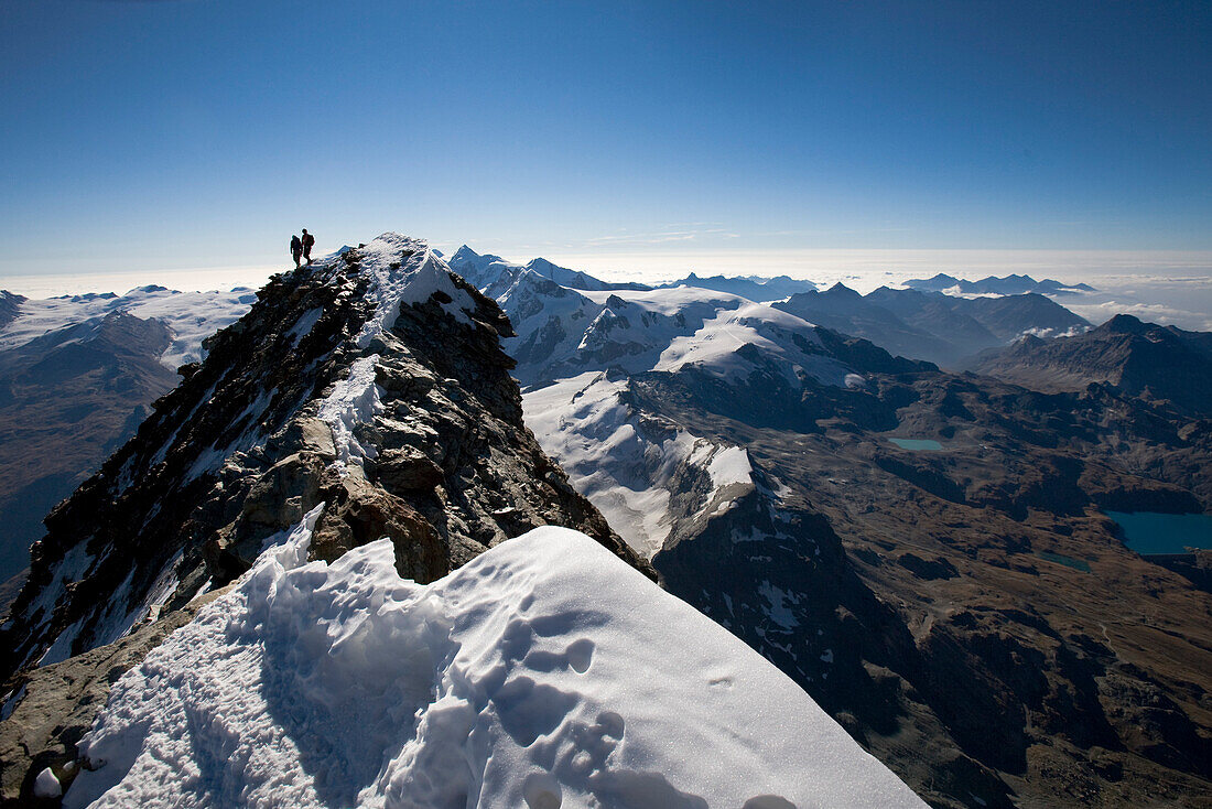 Two mountaineers on summit of mount Matterhorn, Canton of Valais, Switzerland