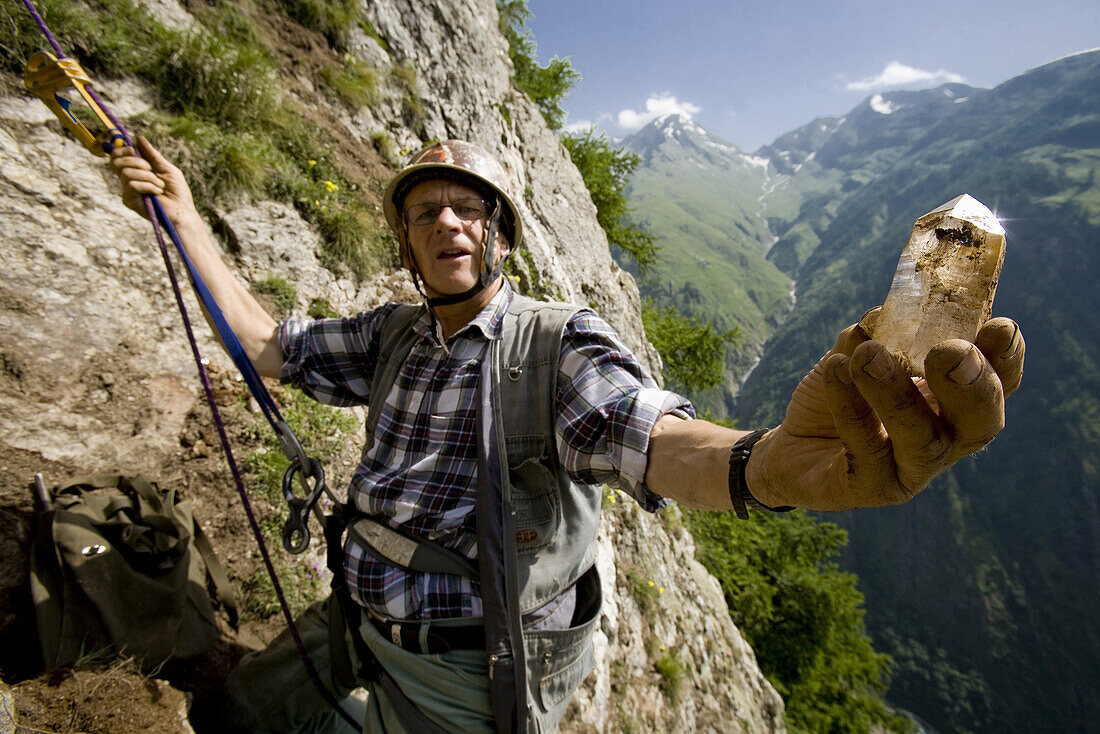 Rockhounder holding a rock crystal, Baldschieder Valley, Bernese Alps, Canton of Valais, Switzerland