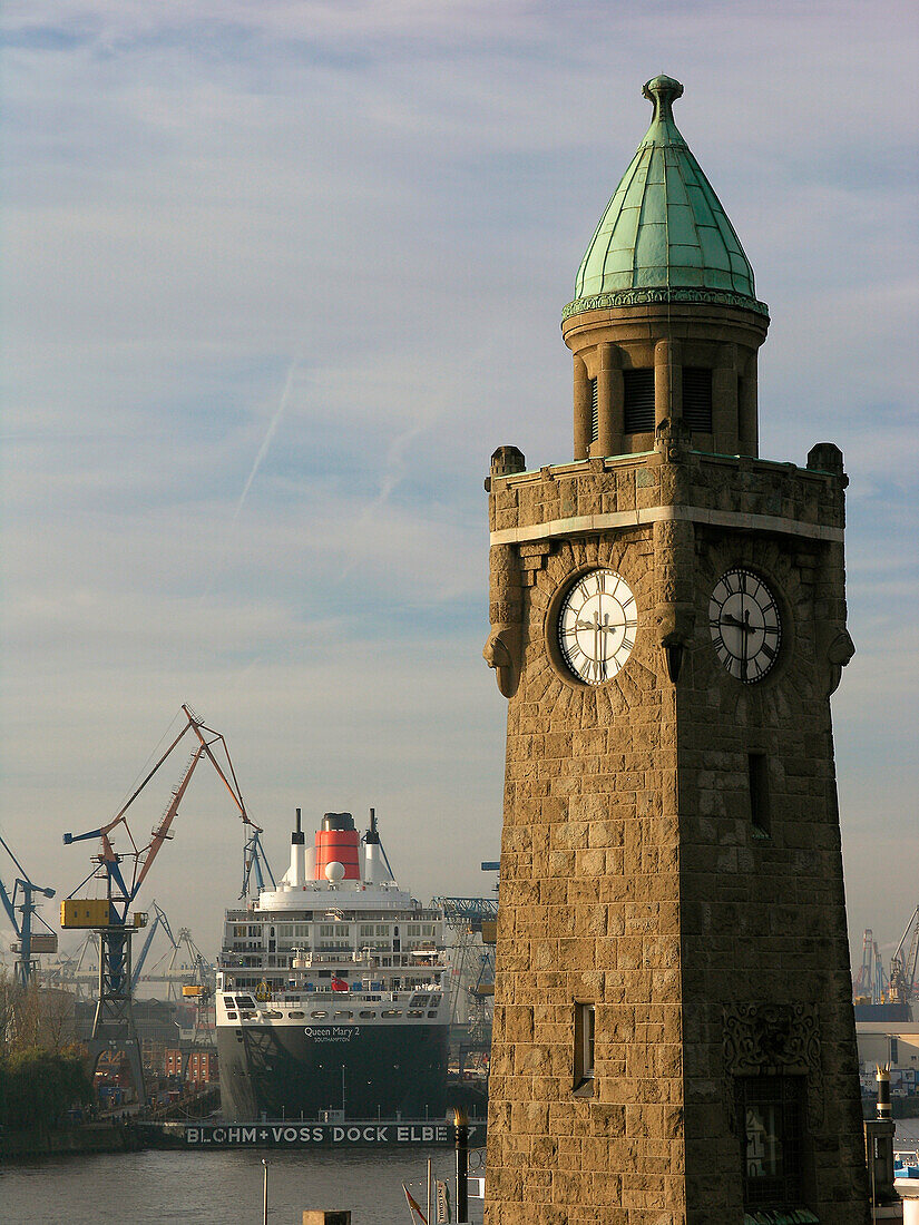 Ein Uhrenturm und Kreuzfahrtschiff Queen Mary 2 in der Werft, Hansestadt Hamburg, Deutschland