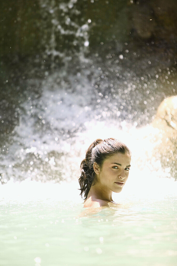 Woman under waterfall