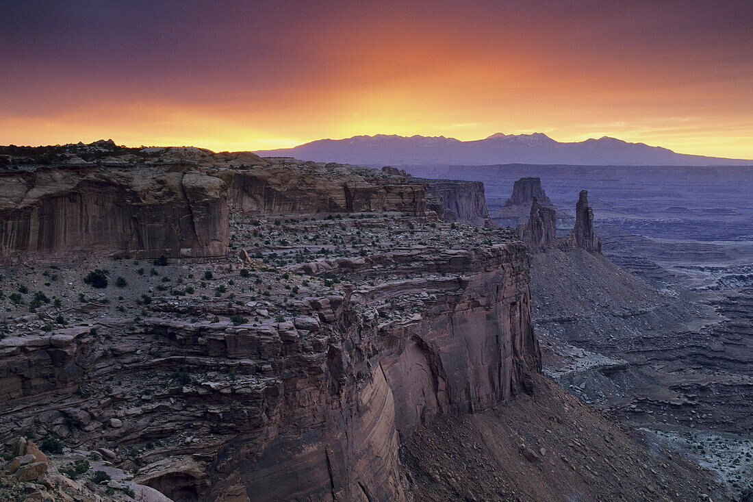 Stormy sunrise over the LaSal Mtns and red rock cliffs from Mesa Arch, Island in the Sky, Canyonlands NP, Utah, USA