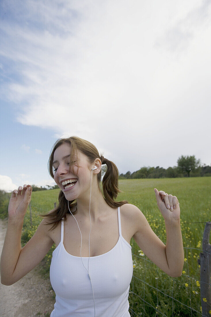 asians, Color, Colour, Contemporary, Country road, Country roads, Daytime, Earphone, Earphones, Exterior, Facial expression, Facial expressions, Female, Fence, Fences, Field, Fields, Flower, Flowers