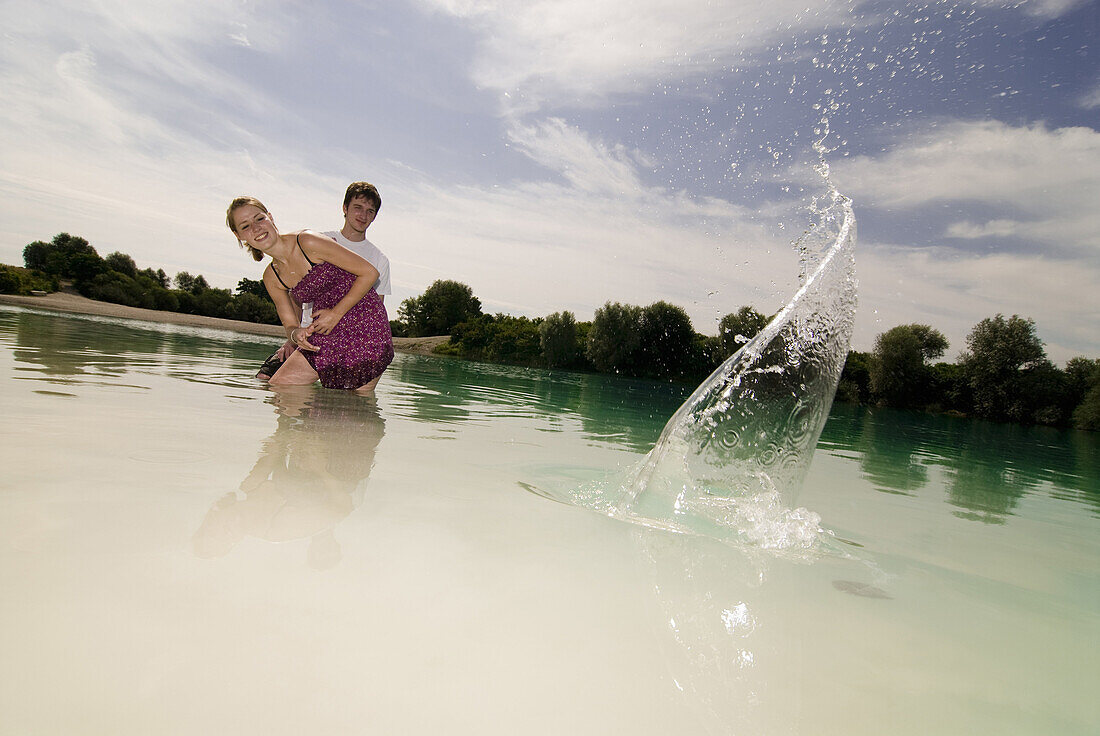 Junges Paar läßt Steine übers Wasser hüpfen, Freising, Bayern, Deutschland