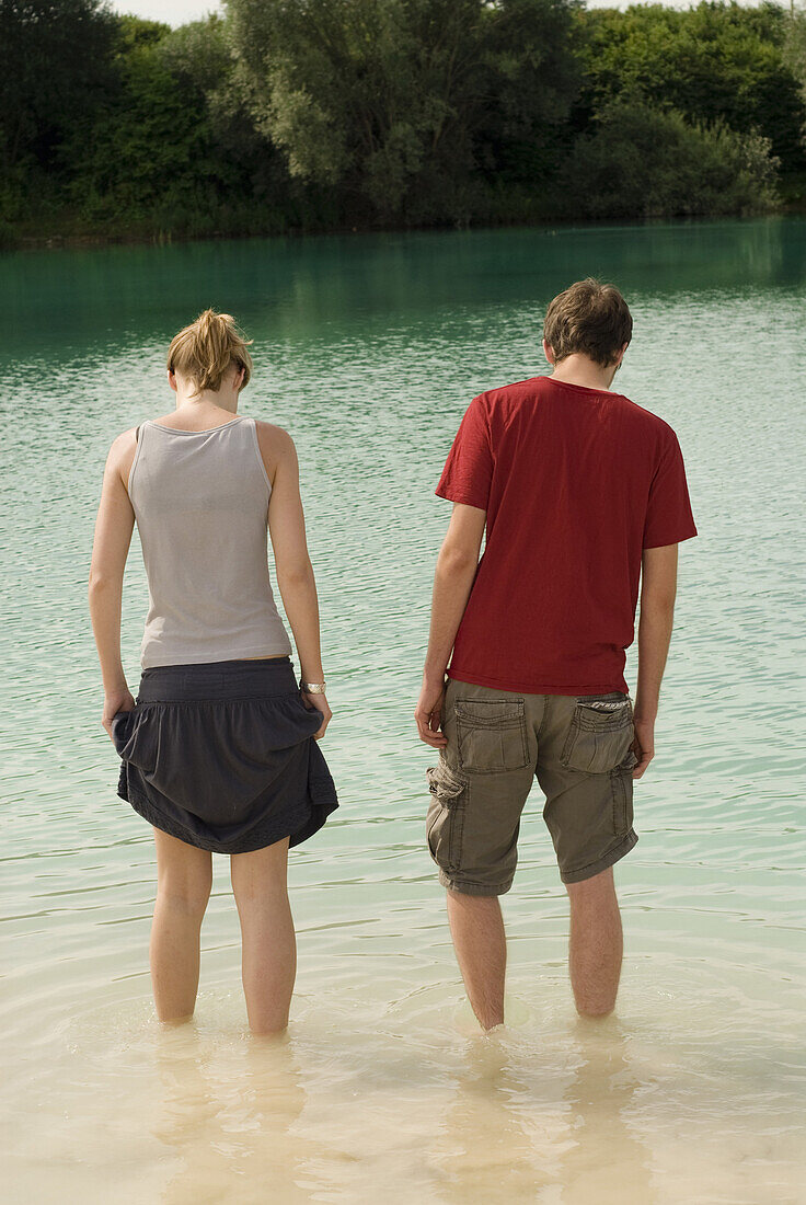 Young couple standing in quarry pond, Freising, Bavaria, Germany