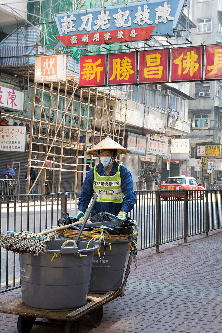 Street sweeper wearing dust mask in Chinatown, Yau Ma Tei, Kowloon, Hong Kong, China, Asia
