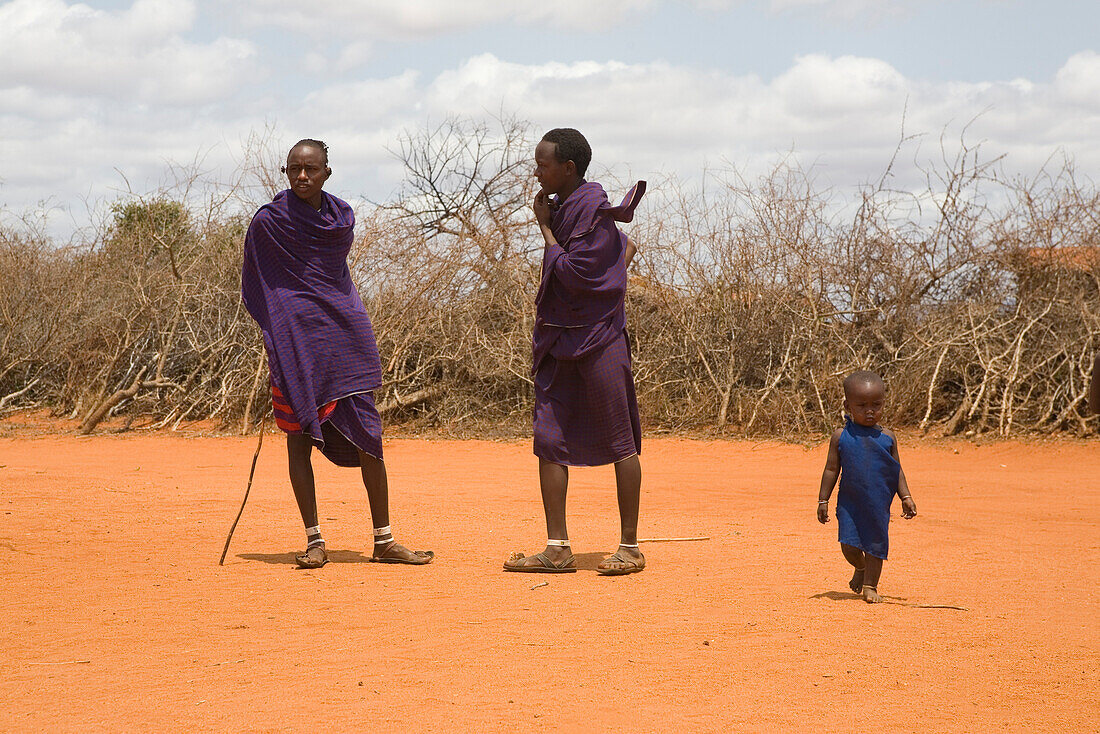 Massai men and small child in the sunlight, Tsavo, Kenya, Africa