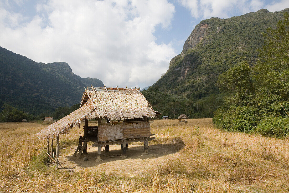 Strohgedeckte Hütte in den Feldern unter Wolkenhimmel, Provinz Luang Prabang, Laos