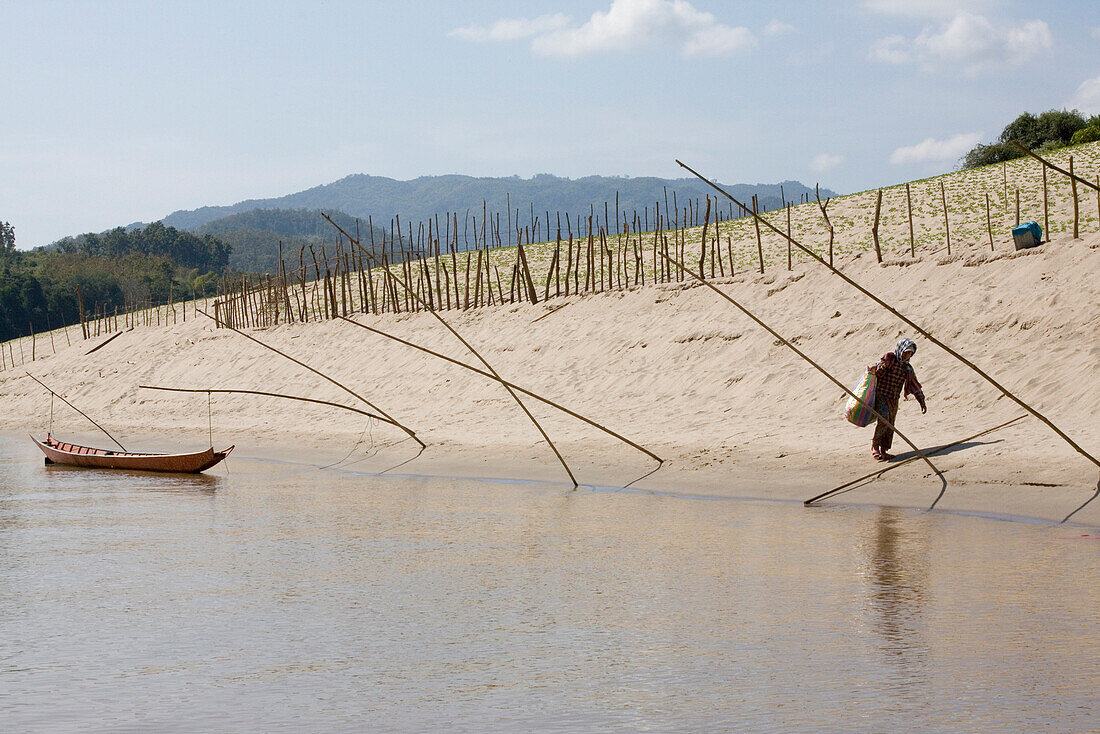 Fishing boat and woman at the bank of the Mekong River, Xaignabouri Province, Laos