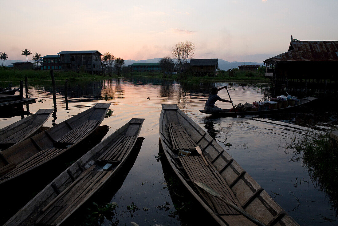 Paddelboote und Frau im Paddelboot bei Abendstimmung am Inle See, Shan Staat, Myanmar, Burma