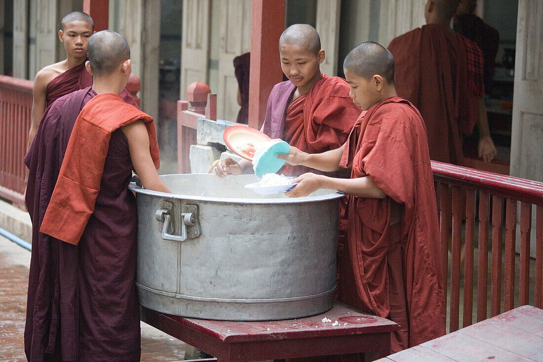 Buddhistische Mönche bei der Essensausgabe von Reis im Mahagandhayon Kloster in Amarapura bei Mandalay, Myanmar, Burma