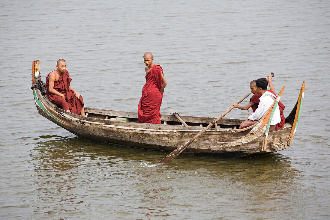 Buddhisthische Mönche in einem Ruderboot auf dem Taungthaman See in Amarapura bei Mandalay, Myanmar, Burma