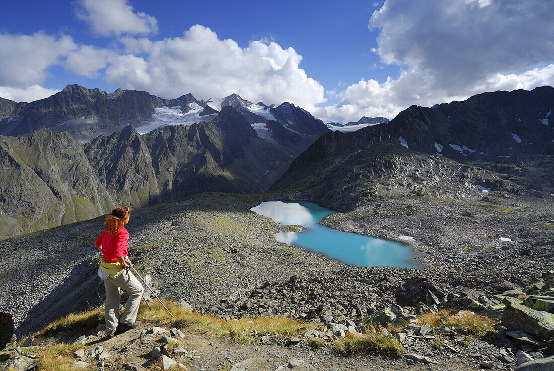 Woman looking to lake Rinnensee, Stubai Alps, Stubai, Tyrol, Austria