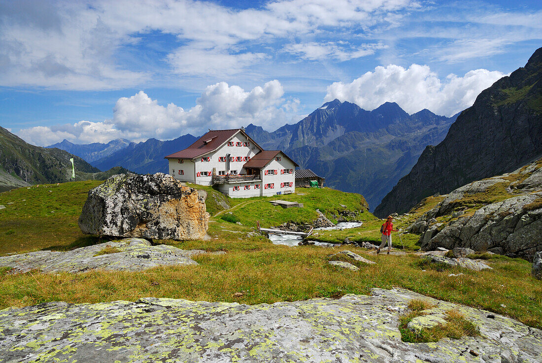 hiker in front of hut Neue Regensburger Huette with Habicht, Stubaier Alpen range, Stubai, Tyrol, Austria