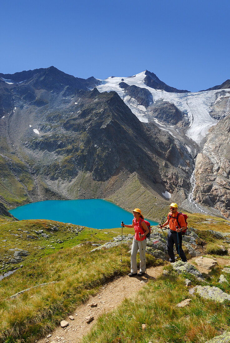 Paar auf Wanderweg über dem Grünausee, Wilder Freiger mit Wilder-Freiger-Ferner im Hintergrund, Stubaier Alpen, Stubai, Tirol, Österreich