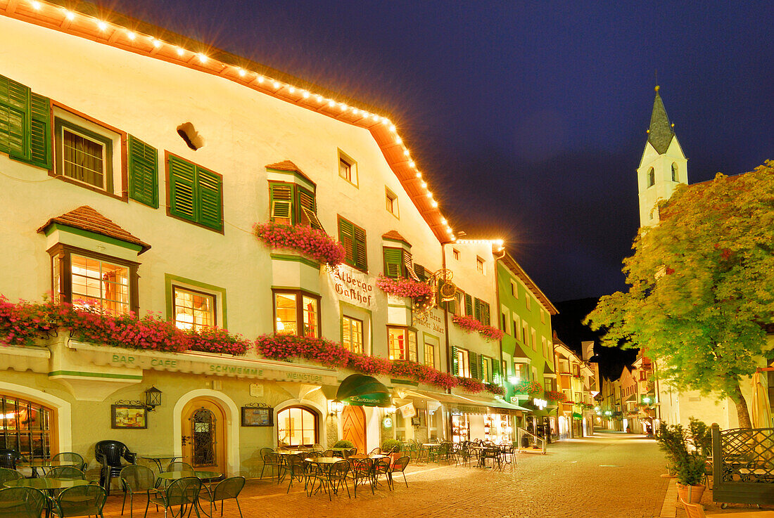 Gasthof, Kirche und Fußgängerzone in Sterzing, beleuchtet in der Dämmerung, Sterzing, Südtirol, Italien