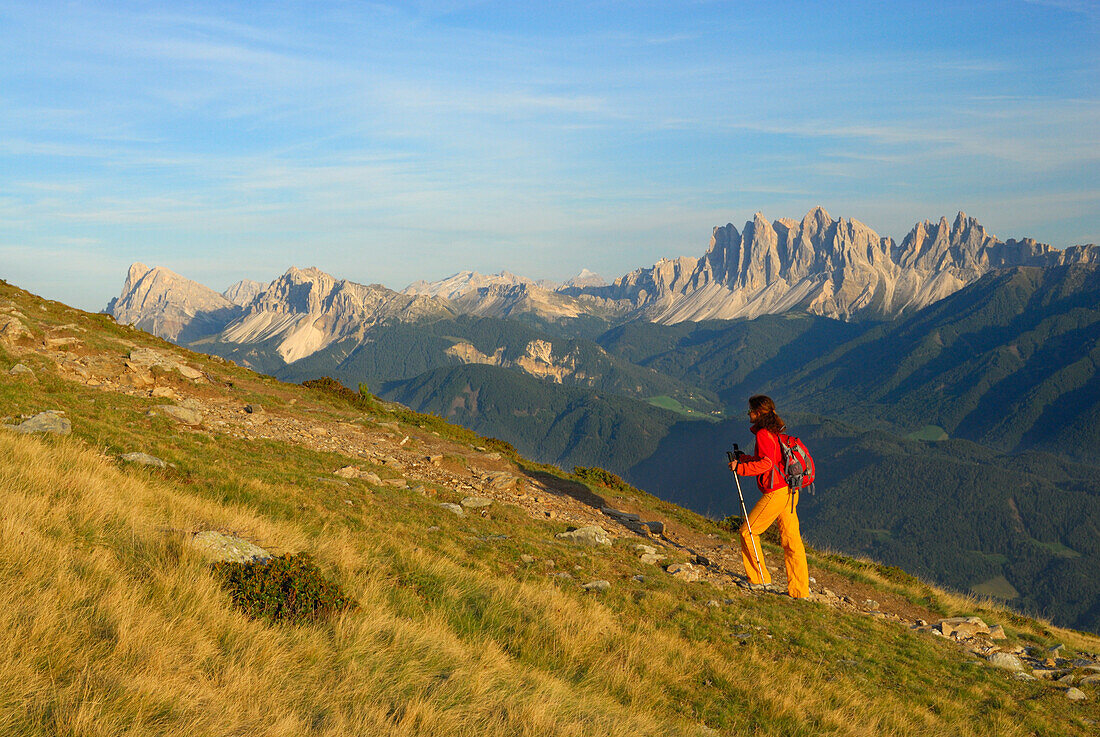 young woman on trail with view to Dolomites with Peitlerkofel and Geislergruppe range, Radlseehuette, Sarntaler Alpen, Sarntal range, South Tyrol, Italy