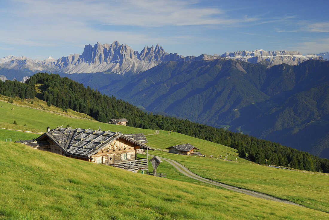 View over alpine huts to Dolomites with Odle range and Sella range, South Tyrol, Italy