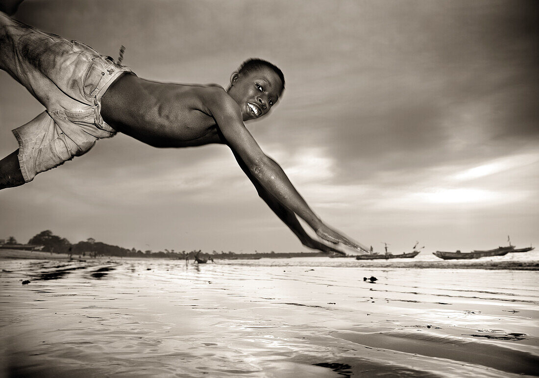 Smiling boy diving. Gambia