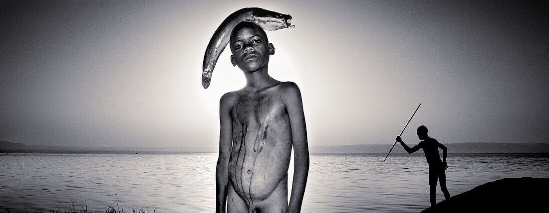 Boy holding fish on his head by Lake Awasa. South Ethiopia. African people