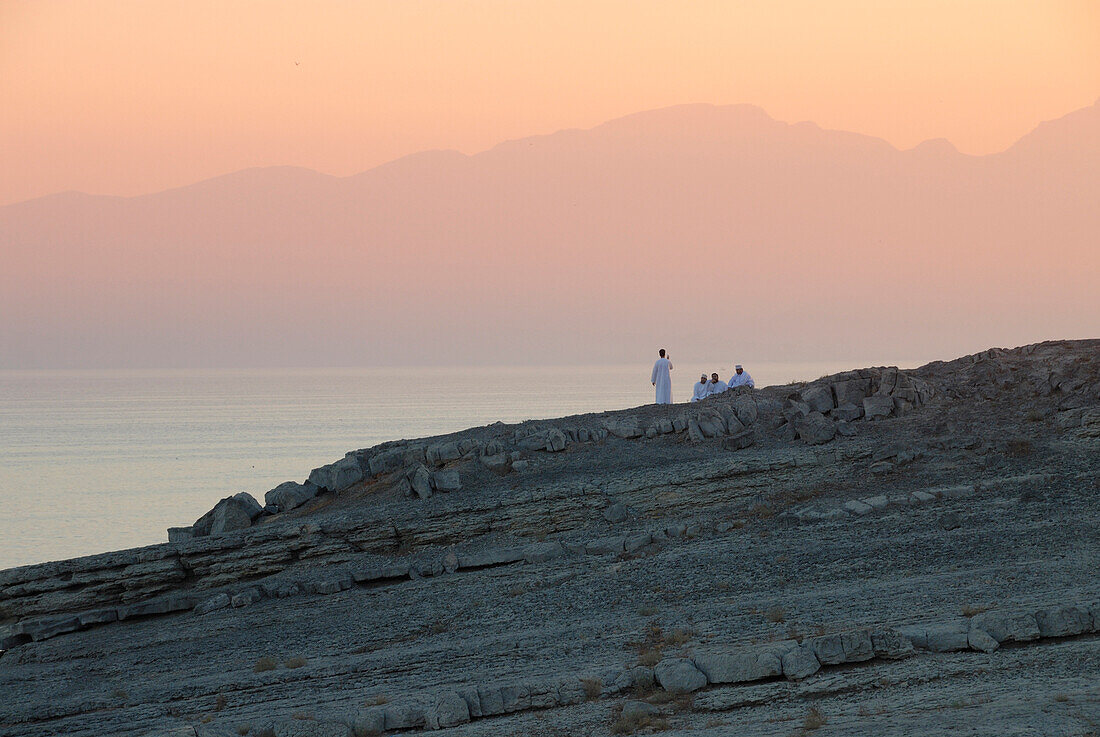 Einheimische bei Sonnenuntergang an der Küste, Musandam, Oman, Asien