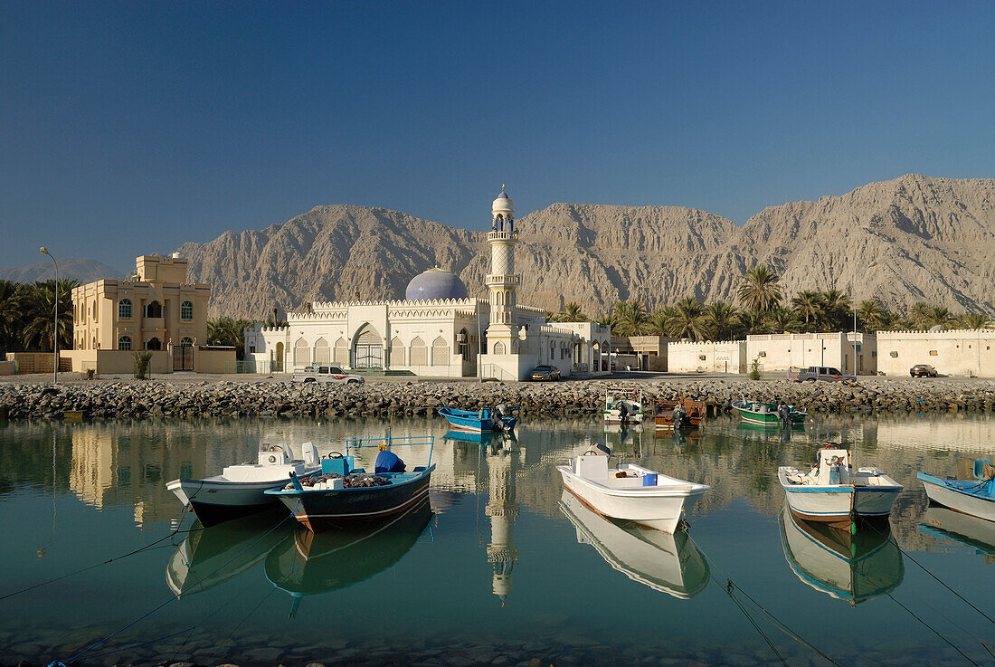 Blick auf Hafen mit Fischerbooten und eine Moschee im Sonnenlicht, Khasab, Musandam, Oman, Asien