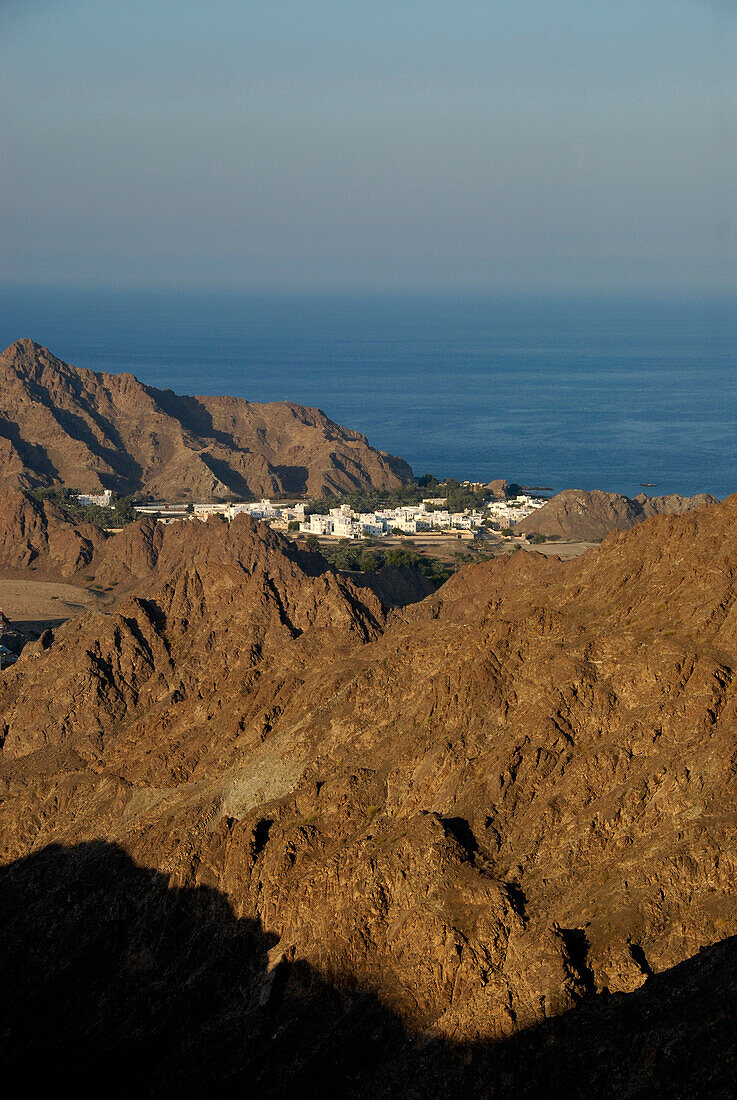 View at houses on rocky coast in the sunlight, Oman, Asia