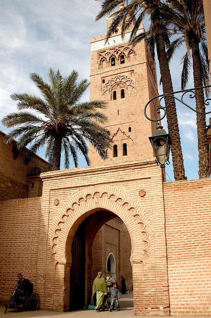 Menschen gehen durch ein Tor der Kutubiya Moschee, Marrakesch, Marokko, Afrika