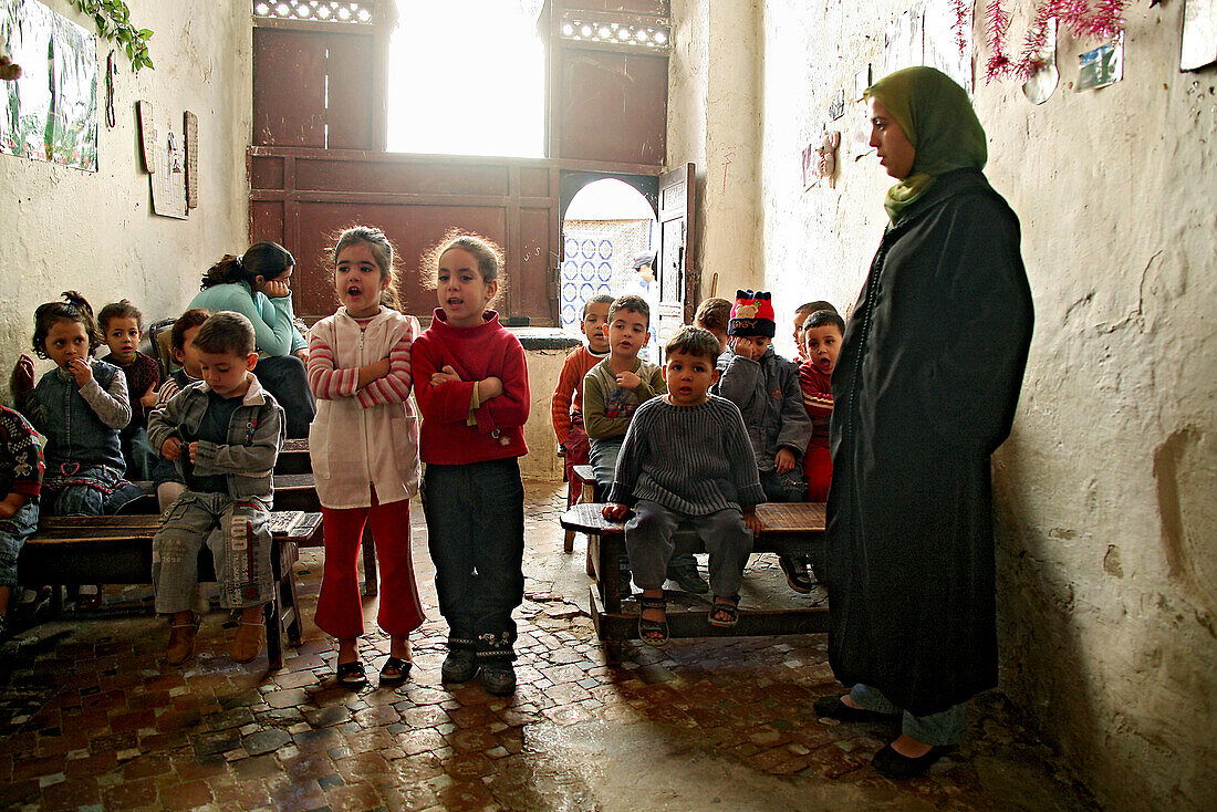 Schüler und Lehrerin in einer kleinen Koranschule in der Medina von Fès, Marokko, Afrika