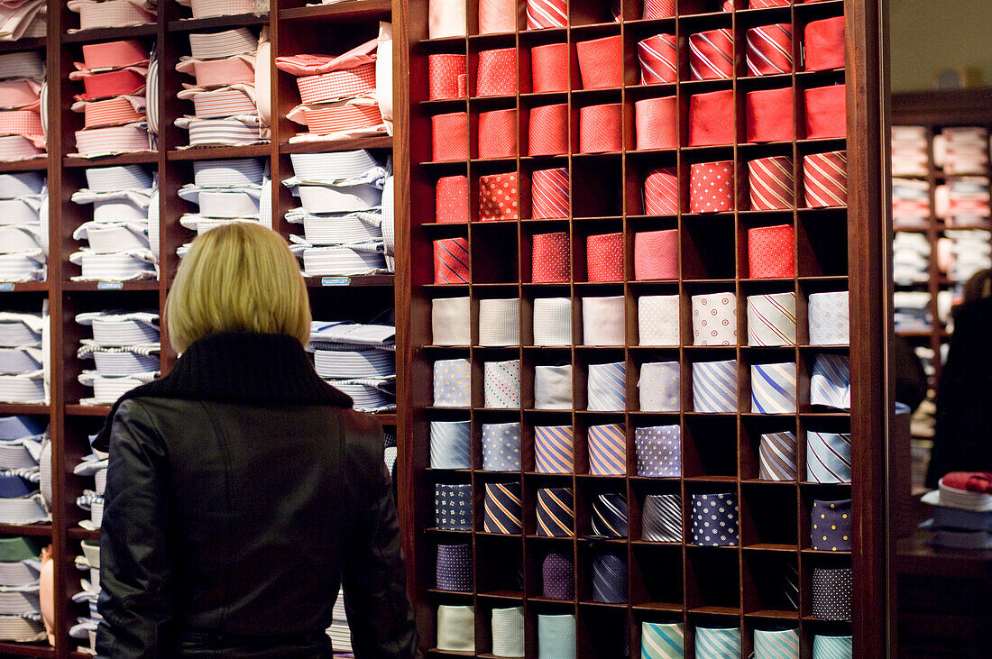 Frau im Herrenbekleidungsladen sucht Krawatten und Hemden, Ingolstadt, Bayern, Deutschland