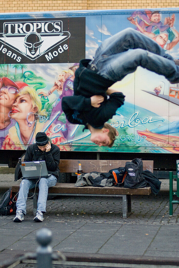 Jugendlicher macht einen Salto, Junge Mann mit Laptop, Freizeit, Ingolstadt, Bayern, Deutschland