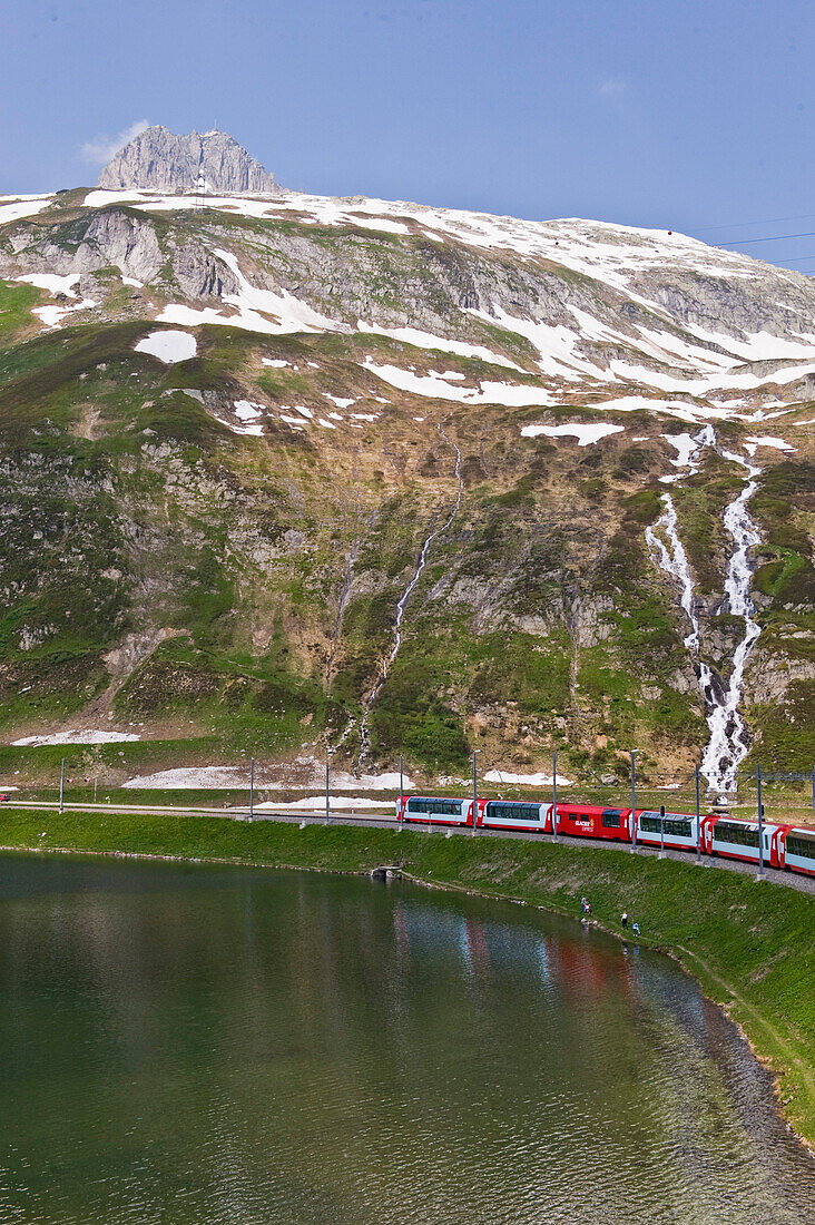 Zug fährt am See vorbei, Berglandschaft, Furka Pass, Schweiz