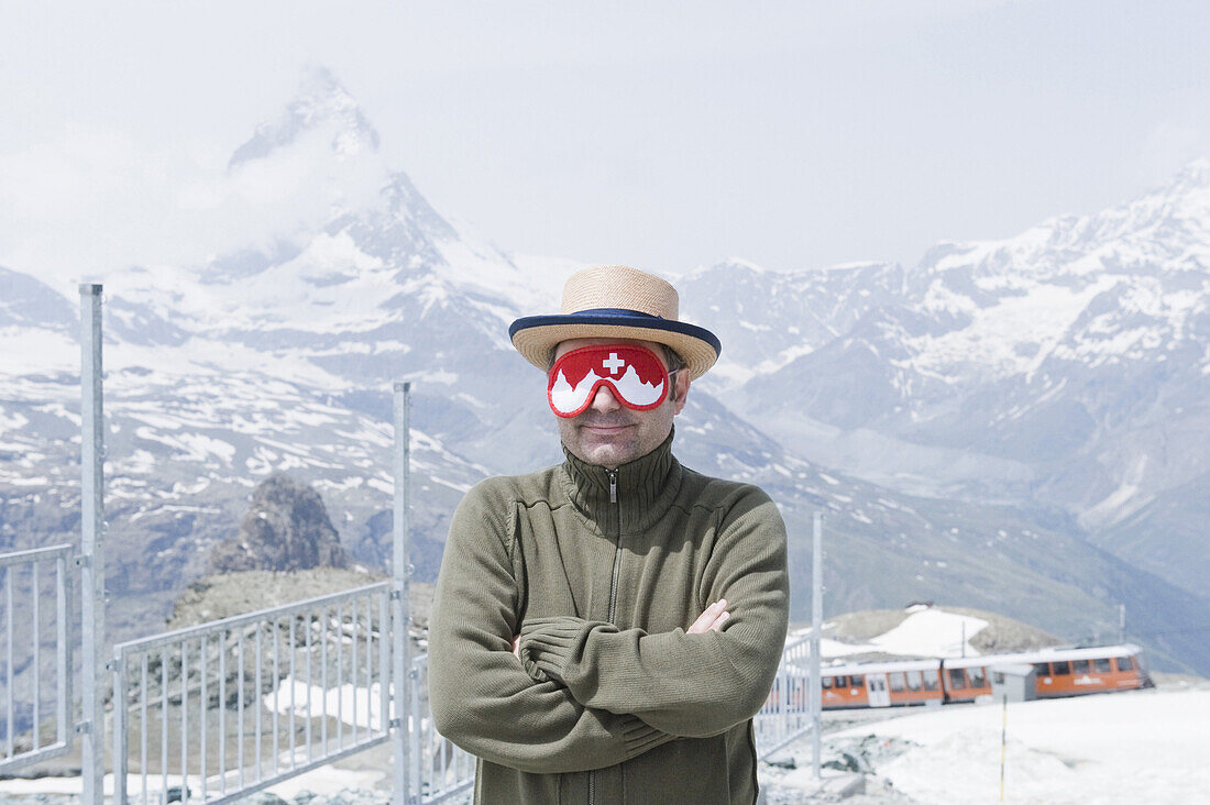 Mann wearing a sleeping mask, Mountain landscape, Valais, Switzerland