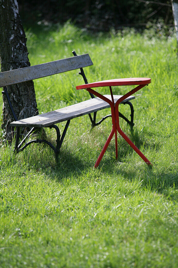 Old garden bench and a table on green meadow