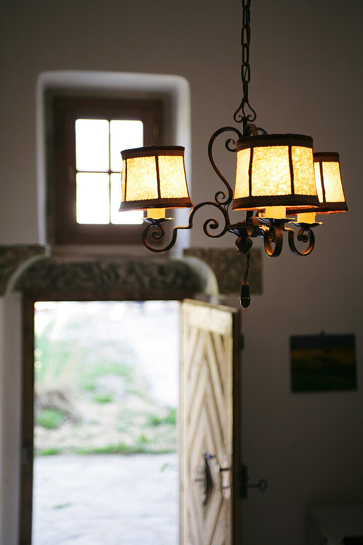 Fresh air and the view into a garden, illuminated, antique lamp and an open door
