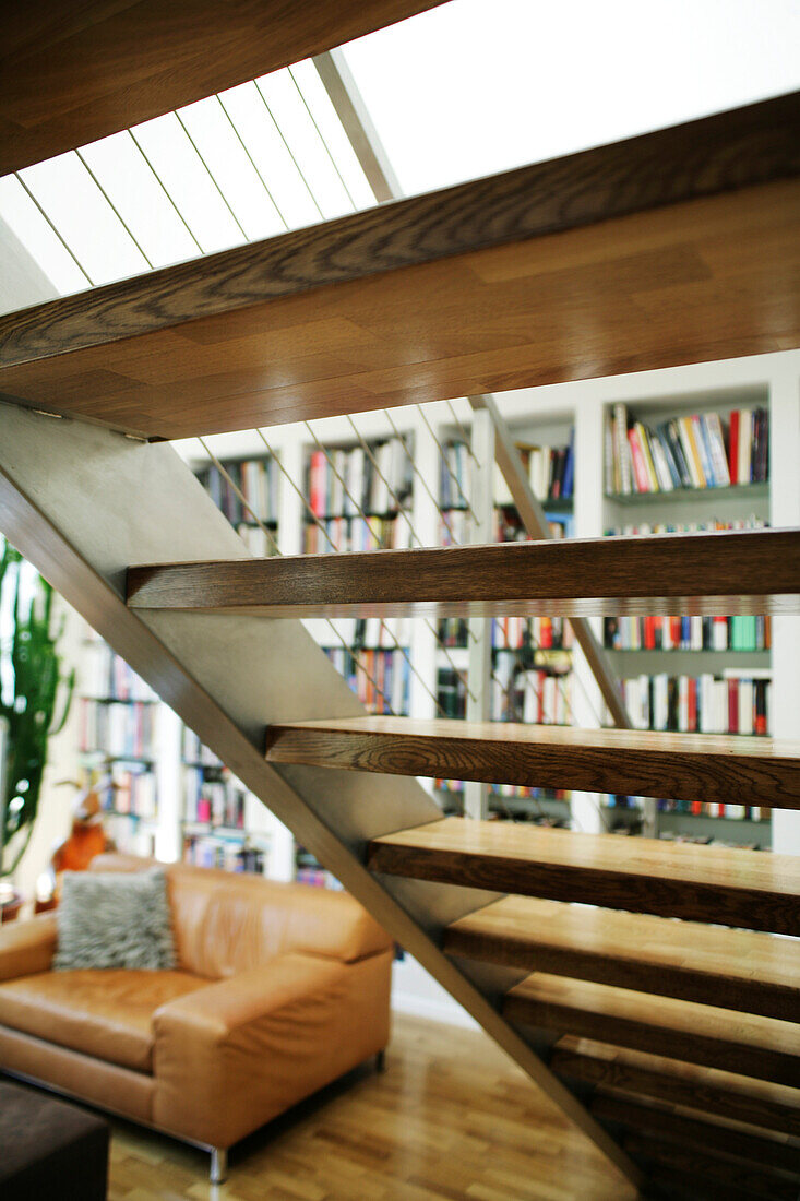 Wohnzimmermöbel mit Sofa, Treppe und Bücherregalen im Loftstyle