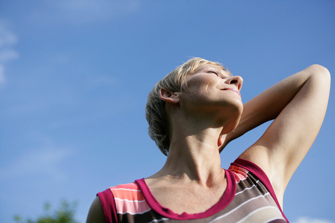 Mature woman stretching in sun, Styria, Austria