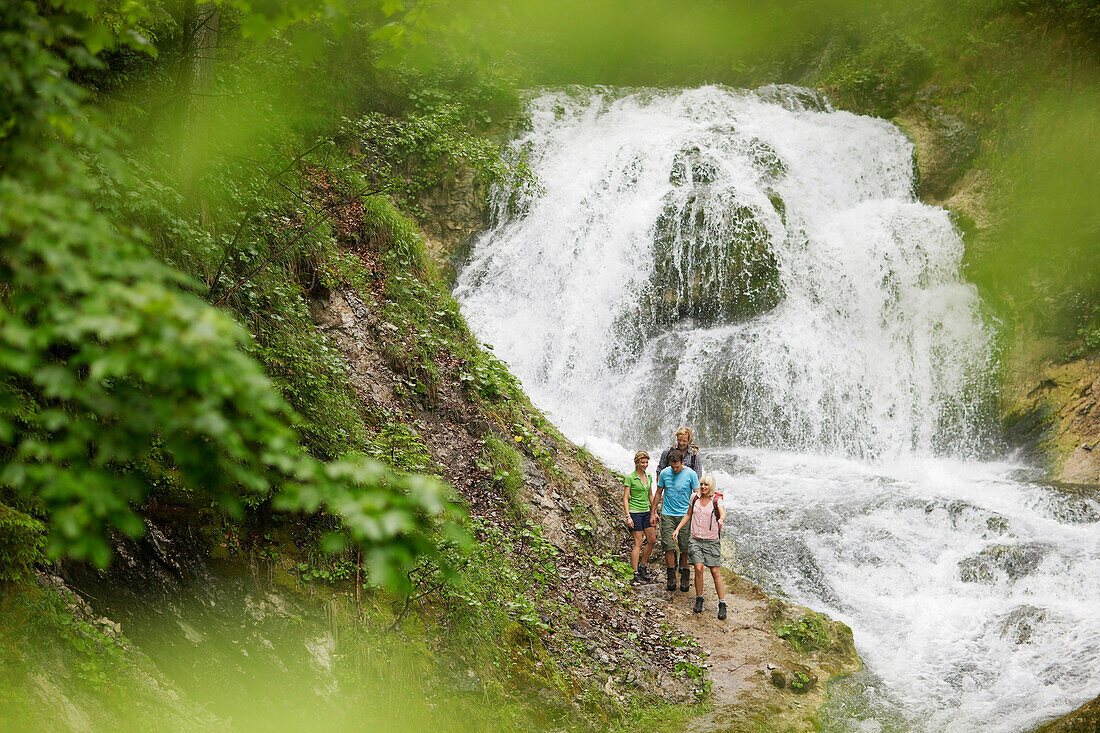 Hikers near waterfall, Werdenfelser Land, Bavaria, Germany