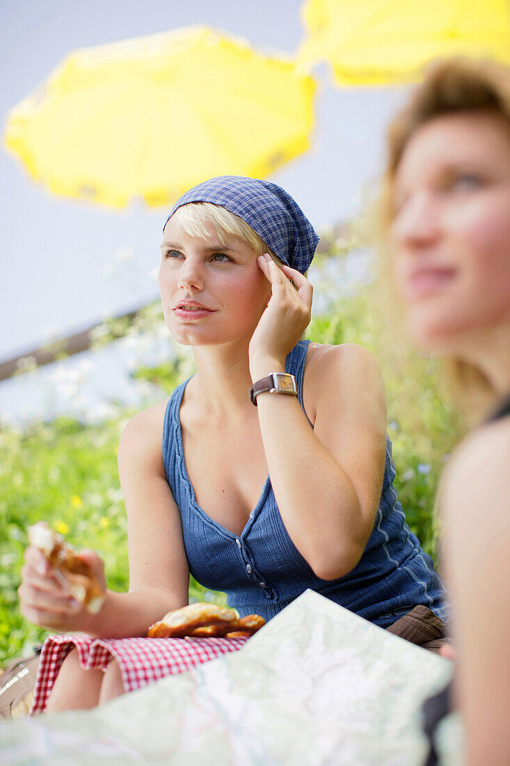 Two young woman having a picnic, Werdenfelser Land, Bavaria, Germany
