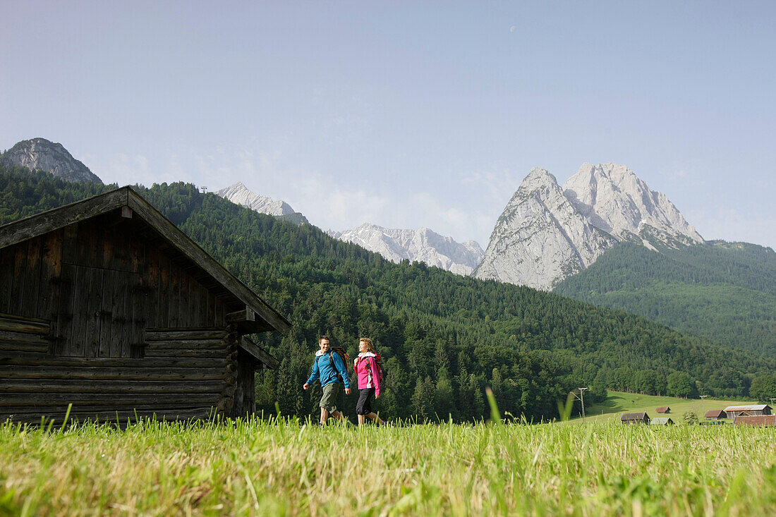 Hikers near alpine lodge, Werdenfelser Land, Bavaria, Germany
