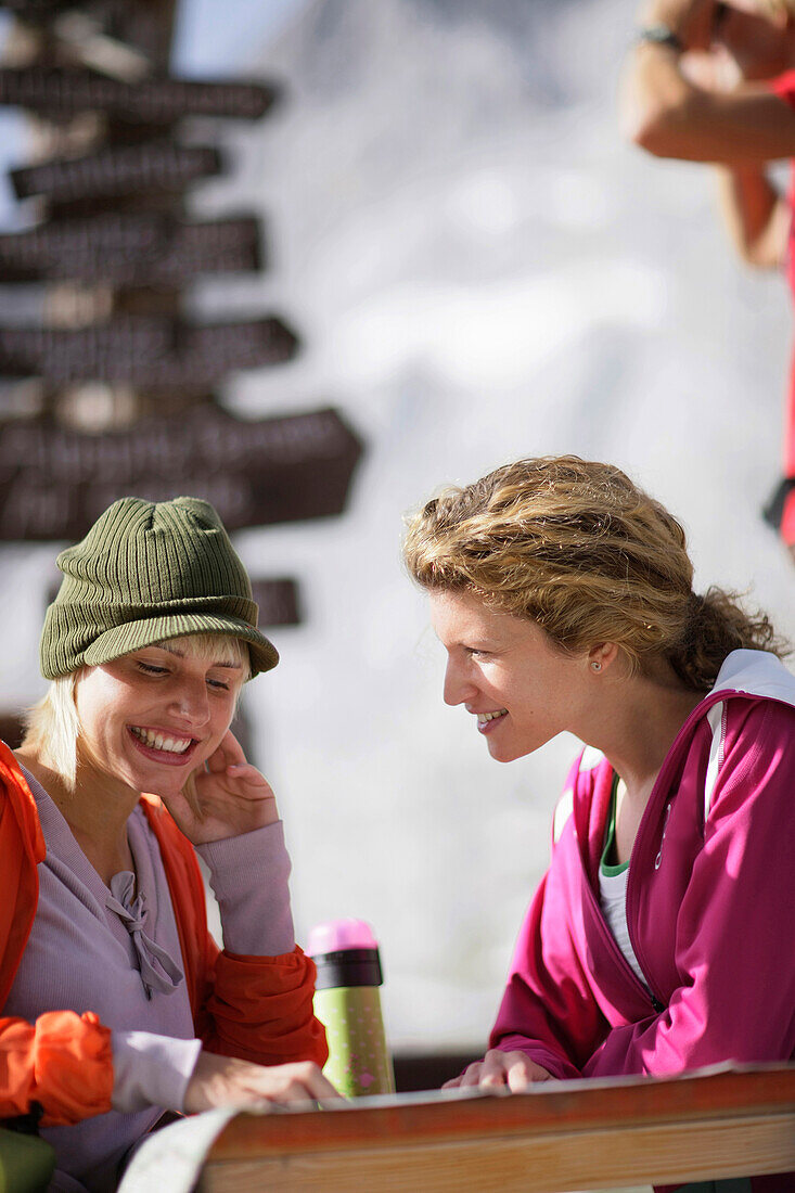 Two young women near sign post, Werdenfelser Land, Bavaria, Germany