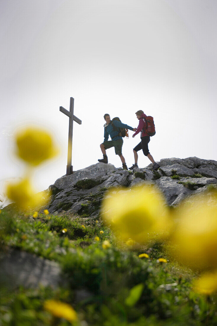 Hikers arriving summit cross, Werdenfelser Land, Bavaria, Germany