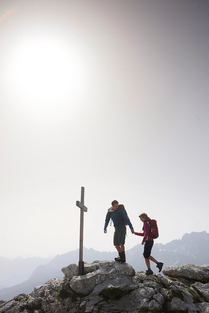 Paar erreicht Gipfelkreuz, Werdenfelser Land, Bayern, Deutschland