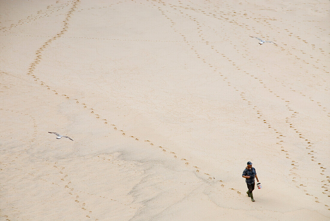 Fischer läuft am Strand entlang, Ericeira, Portugal, Atlantik