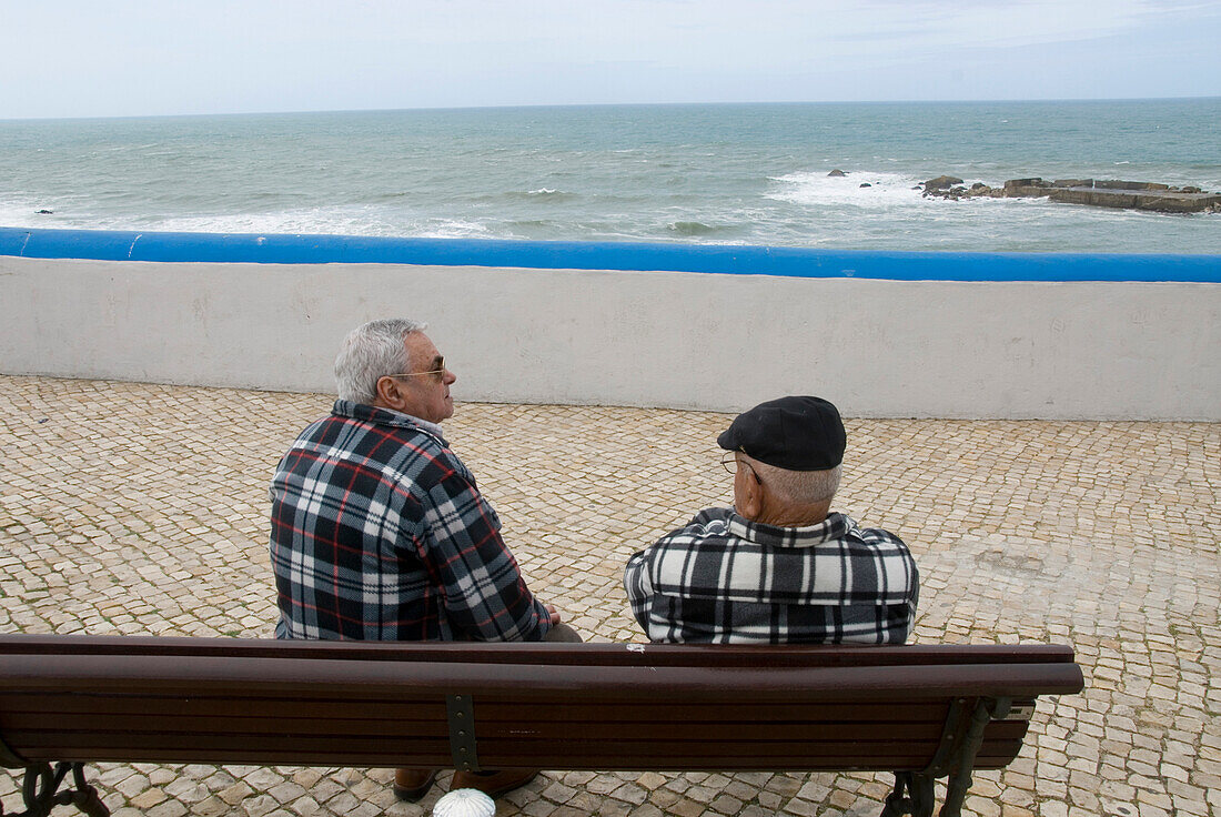 Zwei ältere Männer, Fischer, sitzen auf einer Bank, Meerblick, Ericeira, Portugal, Atlantik