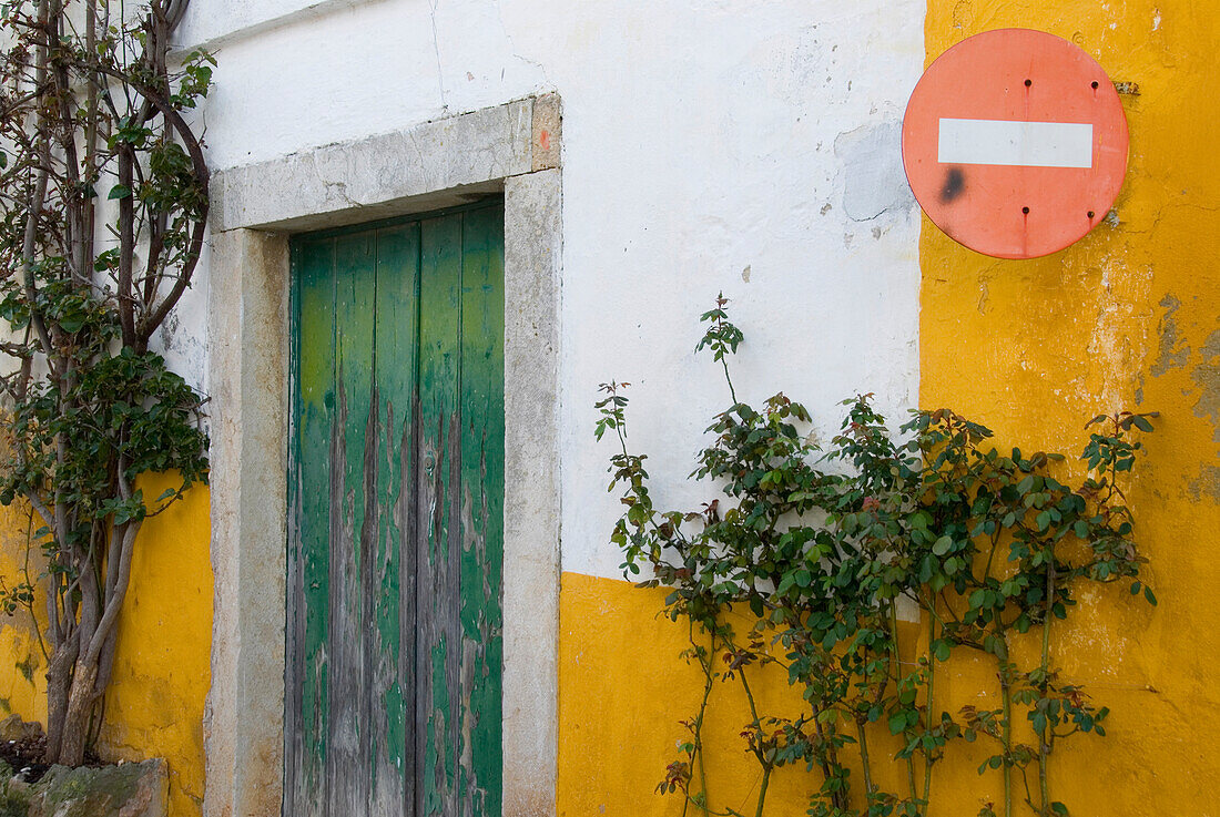 Yellow and white painted house with No entry sign, Old town of Obidos, Leiria, Estremadura, Portugal