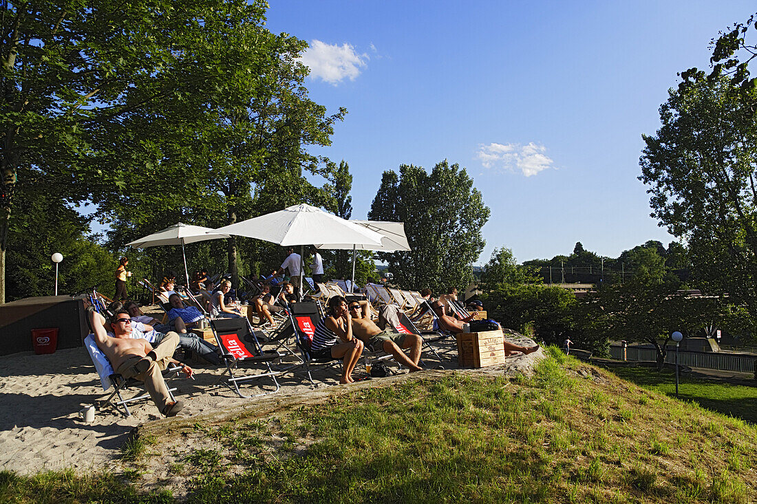 People relaxing in a beach bar at river Neckar, Seilerwasen, Bad Cannstatt, Stuttgart, Baden-Wurttemberg, Germany